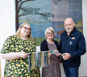 Paul Stewart, WWT Castle Espie Centre Manager, Dr Sally Montgomery, Northern Ireland Committee Member at The National Lottery Heritage Fund, Claire Anketell, Director of Inspiring Yarns CIC and Creative Director Åsa McDowell, who composed and designed the four large panels.